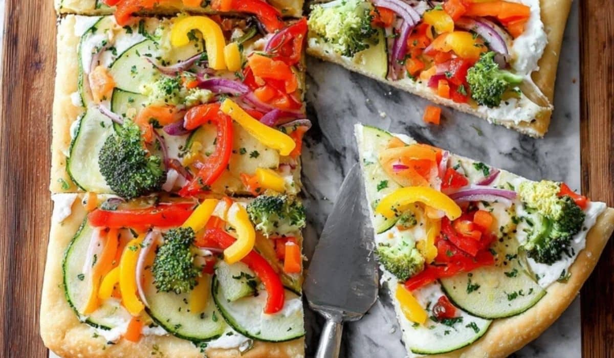 Crescent roll veggie pizza with cream cheese spread and colorful fresh vegetables
