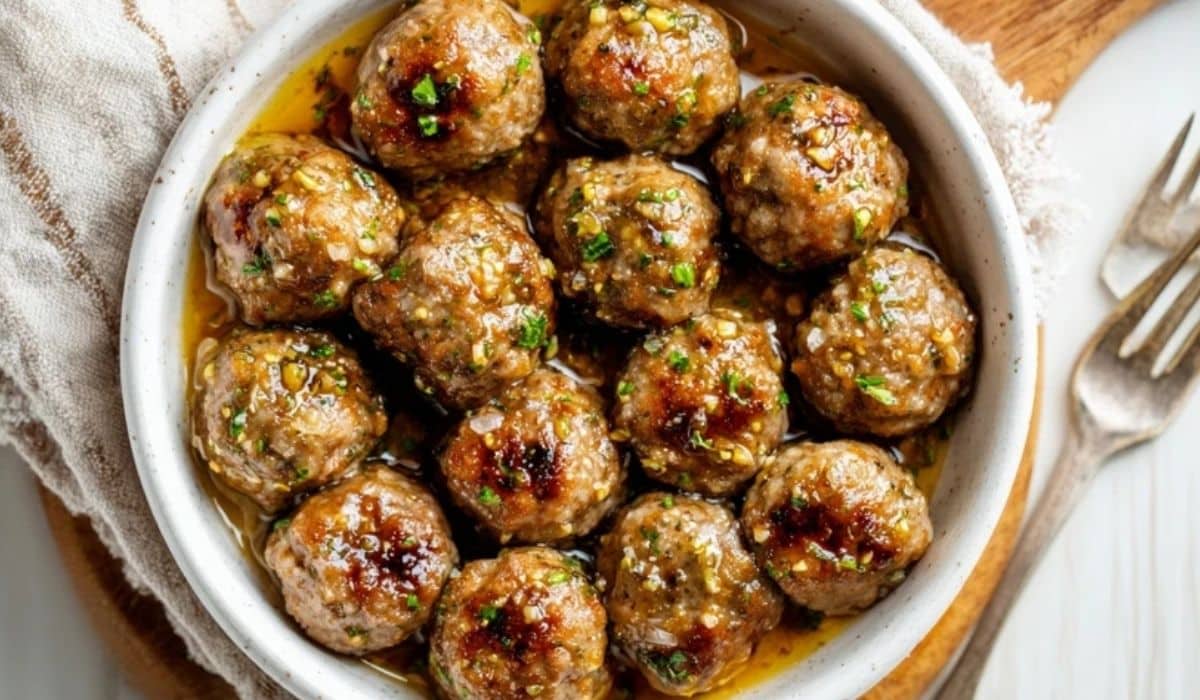 Keto Garlic Butter Meatballs served in a white bowl with garlic butter sauce