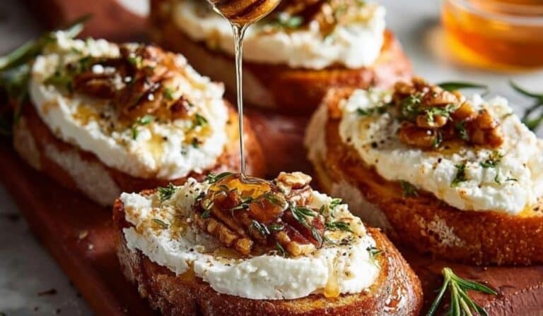 Featured image of Spicy Honey Drizzled Feta Crostini Delight on rustic wood board with rosemary and golden honey drizzle