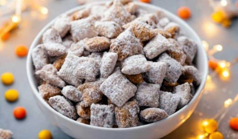 Peanut Butter Puppy Chow served in a white bowl dusted with powdered sugar