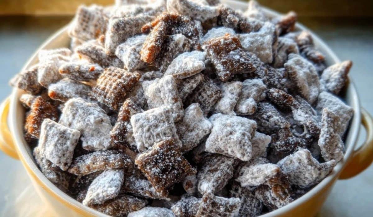 Bowl of homemade Puppy Chow Chex Mix Recipe coated with powdered sugar