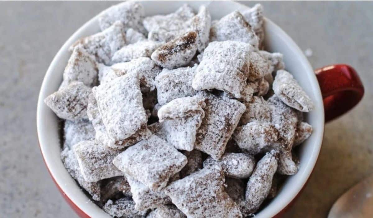 Easy Puppy Chow Recipe snack bowl with powdered sugar coating