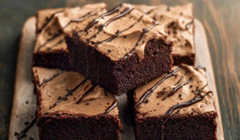 Guinness Brownies stacked on a ceramic plate with melted chocolate drizzle