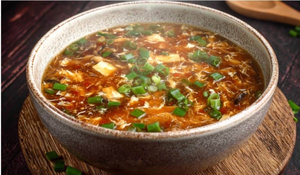 Chinese Hot and Sour Soup in ceramic bowl on wooden table