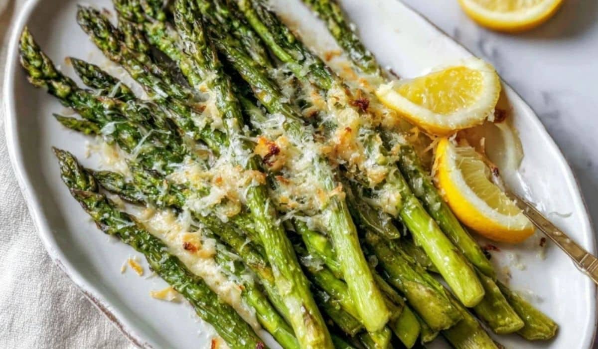 Roasted asparagus lemon parmesan on a platter with golden cheese and lemon zest