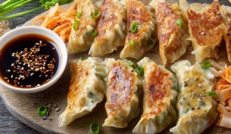 Vegan cabbage dumplings with tofu on a platter with dipping sauce